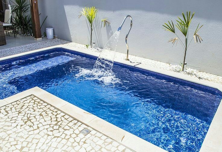 56 – Área de lazer com piscina em alvenaria em L. Bordas em mármore, fonte em inox