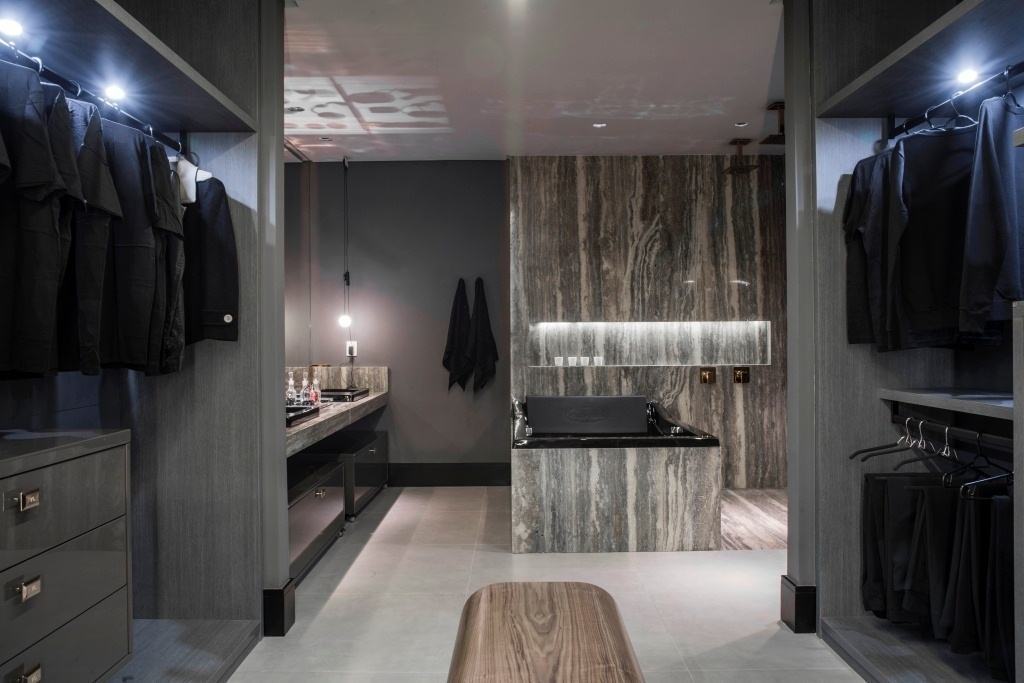Suíte Master 35 –Neste projeto mais masculino o cinza e o preto predominam tanto no closet, quanto no banheiro que conta com uma banheira em estilo tradicional preta.