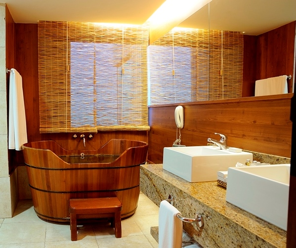 35. Banheiro em estilo rústico com banheira ofurô de imersão em madeira e pia dupla.
