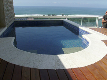 Bordas de piscina 22 - Piscina com borda atérmica peito de pomba, com piso externo em madeira.